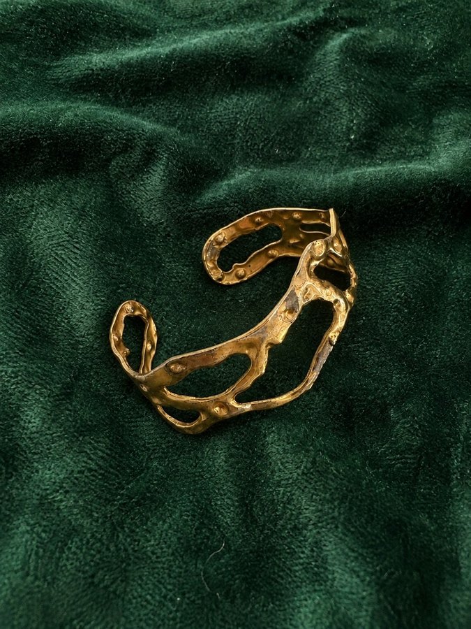 Bracelet doré, posé sur du velours